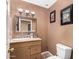 Cozy half bath with a stylish mirror, vanity, and toilet at 706 N Signal Butte Rd, Mesa, AZ 85207