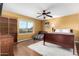 Bedroom with hardwood floors, ceiling fan and view to the outdoors at 706 N Signal Butte Rd, Mesa, AZ 85207