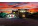 Stunning desert home featuring a vibrant red door and a picturesque sunset backdrop at 706 N Signal Butte Rd, Mesa, AZ 85207