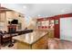 Kitchen with island, stainless appliances, and adjacent living room with fireplace at 706 N Signal Butte Rd, Mesa, AZ 85207