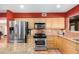 Kitchen with island, stainless appliances, and neutral wood cabinets at 706 N Signal Butte Rd, Mesa, AZ 85207