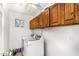 Bright laundry room with wooden cabinets above the side-by-side washer and dryer at 706 N Signal Butte Rd, Mesa, AZ 85207