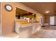 Outdoor kitchen with countertop, sink, bar and a pass through to the kitchen at 706 N Signal Butte Rd, Mesa, AZ 85207