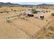 Aerial view of property with multiple horse pens, trailers, and dwellings under an overcast sky at 7209 N Maple St, Maricopa, AZ 85139