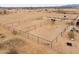 Aerial view of fenced in horse pens on sandy land with horses under an overcast sky at 7209 N Maple St, Maricopa, AZ 85139