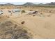 Aerial view of the property showing the fenced horse pens and arid land under an overcast sky at 7209 N Maple St, Maricopa, AZ 85139