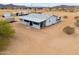 Home exterior with covered porch, set in a desert landscape with ample space and trailer parking at 7209 N Maple St, Maricopa, AZ 85139