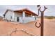 Quaint single-story home featuring a covered porch, xeriscaping, and a horseshoe design, all set against a desert backdrop at 7209 N Maple St, Maricopa, AZ 85139