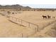 Fenced horse pen with three horses on sandy ground, under an overcast sky at 7209 N Maple St, Maricopa, AZ 85139