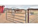 Gated horse property with sandy ground and mountain views in the distance under cloudy skies at 7209 N Maple St, Maricopa, AZ 85139
