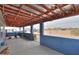 Covered patio with partial walls, desert landscape, electric bicycle, and wood beams at 7209 N Maple St, Maricopa, AZ 85139