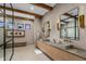 Contemporary bathroom featuring dual vanities, stylish lighting, and stone tile flooring at 8307 E Gary Rd, Scottsdale, AZ 85260