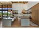 Modern kitchen with large island, stone backsplash, wooden cabinets and stylish hanging lights at 8307 E Gary Rd, Scottsdale, AZ 85260