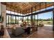 Bright living room with expansive windows, wood ceiling and hardwood floors opens to patio at 8307 E Gary Rd, Scottsdale, AZ 85260