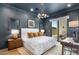 Well-lit main bedroom with a statement light fixture, hardwood floors and patio access at 8307 E Gary Rd, Scottsdale, AZ 85260