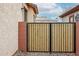 Wood and metal gate leading to the backyard with stacked block accents and low maintenance landscaping at 859 S Bristol --, Mesa, AZ 85208