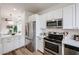 Bright kitchen featuring stainless steel appliances, white cabinetry and modern backsplash, and quartz countertops at 859 S Bristol --, Mesa, AZ 85208