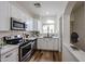 Modern kitchen features stainless steel appliances, white cabinetry, and a window over the sink at 859 S Bristol --, Mesa, AZ 85208