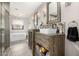 Bright bathroom with double sink, rustic wood vanities, and soaking tub near shower at 923 E Aire Libre Ave, Phoenix, AZ 85022