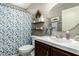 Bathroom with decorative shower curtain, oval mirror, and dark wooden vanity at 923 E Aire Libre Ave, Phoenix, AZ 85022