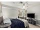 Cozy bedroom featuring a ceiling fan and a TV near a bay window at 923 E Aire Libre Ave, Phoenix, AZ 85022