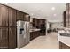 Modern kitchen featuring dark wood cabinetry, stainless steel appliances, and spacious layout for cooking at 923 E Aire Libre Ave, Phoenix, AZ 85022