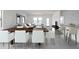 Modern dining room with a dark wood table and seating for six adjacent to a living room at 9815 W Agora Ln, Tolleson, AZ 85353