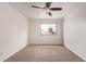 Bright bedroom featuring a ceiling fan, neutral carpet, and a window offering natural light at 1010 E Redfield Rd, Tempe, AZ 85283