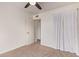 This bedroom has neutral carpet, a ceiling fan, white walls, and a door to another room at 1010 E Redfield Rd, Tempe, AZ 85283