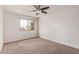 Bright bedroom featuring a ceiling fan, neutral carpet, and large window at 1010 E Redfield Rd, Tempe, AZ 85283