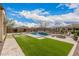 Spacious backyard with a pool, a gas firepit, travertine, and vibrant landscaping at 10717 E Tarragon Ave, Mesa, AZ 85212