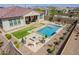 Aerial view of backyard with a sparkling pool, patio with dining set, and lush landscaping at 10717 E Tarragon Ave, Mesa, AZ 85212