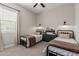 Charming bedroom with twin beds, neutral walls, a ceiling fan and natural light from a window at 10717 E Tarragon Ave, Mesa, AZ 85212