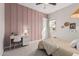 Comfortable bedroom with a pink accent wall, soft lighting, and desk at 10717 E Tarragon Ave, Mesa, AZ 85212