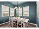 Dining room with modern chandelier, rustic table setting, and large windows at 10717 E Tarragon Ave, Mesa, AZ 85212