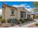 Side view of a stucco home featuring manicured landscaping with vibrant agave plants and well-trimmed bushes at 10717 E Tarragon Ave, Mesa, AZ 85212