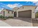 Stucco home with a desert landscape, a paver driveway, and an attached two-car garage at 10717 E Tarragon Ave, Mesa, AZ 85212