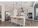 Open kitchen with central island, modern pendant lights, and stainless steel appliances at 10717 E Tarragon Ave, Mesa, AZ 85212