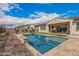 Inviting backyard features a sparkling pool, travertine patio, and covered patio for outdoor living and entertaining at 10717 E Tarragon Ave, Mesa, AZ 85212