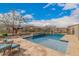 Beautiful backyard pool area with a safety fence, surrounded by well-maintained landscaping and comfortable lounge seating at 10717 E Tarragon Ave, Mesa, AZ 85212