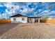 Expansive backyard featuring a well-maintained lawn, white brick home, and a covered patio at 10947 W Mohave St, Avondale, AZ 85323