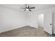 Bedroom with ceiling fan, white walls, wood-look tile floors, and access to a closet and additional room at 10947 W Mohave St, Avondale, AZ 85323