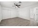 Large bedroom featuring a ceiling fan, closet, and gray wood-look floors at 10947 W Mohave St, Avondale, AZ 85323