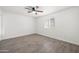 Bedroom with a ceiling fan, window, and gray wood-look floors at 10947 W Mohave St, Avondale, AZ 85323