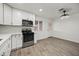 Well-lit kitchen with new appliances, quartz countertops, white cabinets, and gray wood-look flooring at 10947 W Mohave St, Avondale, AZ 85323