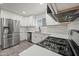 Spacious kitchen features modern stainless steel appliances, white cabinets, and stylish gray floor tiles at 10947 W Mohave St, Avondale, AZ 85323