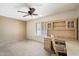 Bedroom with a ceiling fan, built-in desk with shelving and carpeting at 1213 W Esplanade St, Mesa, AZ 85201