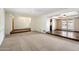 Open-concept living room with neutral carpeting, ceiling fans, and transitions to tiled areas at 1213 W Esplanade St, Mesa, AZ 85201