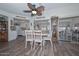 Cozy dining area with wood floors, ceiling fan, and open to kitchen with views of adjacent living room at 13423 W Countryside Dr, Sun City West, AZ 85375