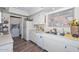 Bright kitchen featuring white appliances, wood floors, and double sink under a large window at 13423 W Countryside Dr, Sun City West, AZ 85375